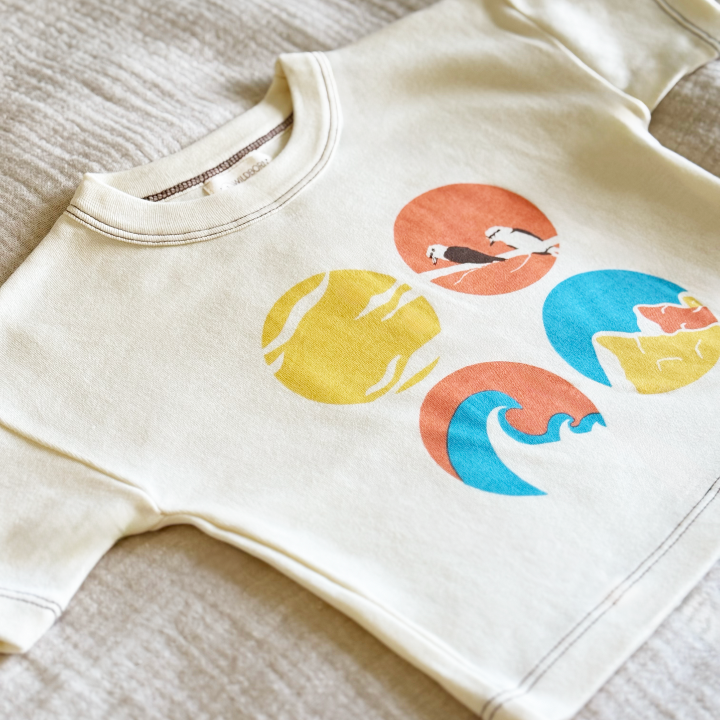 Beige tshirt with colorful graphic design on a textured surface